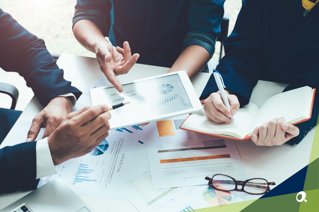 A finance team surrounding a desk discussing financial reports