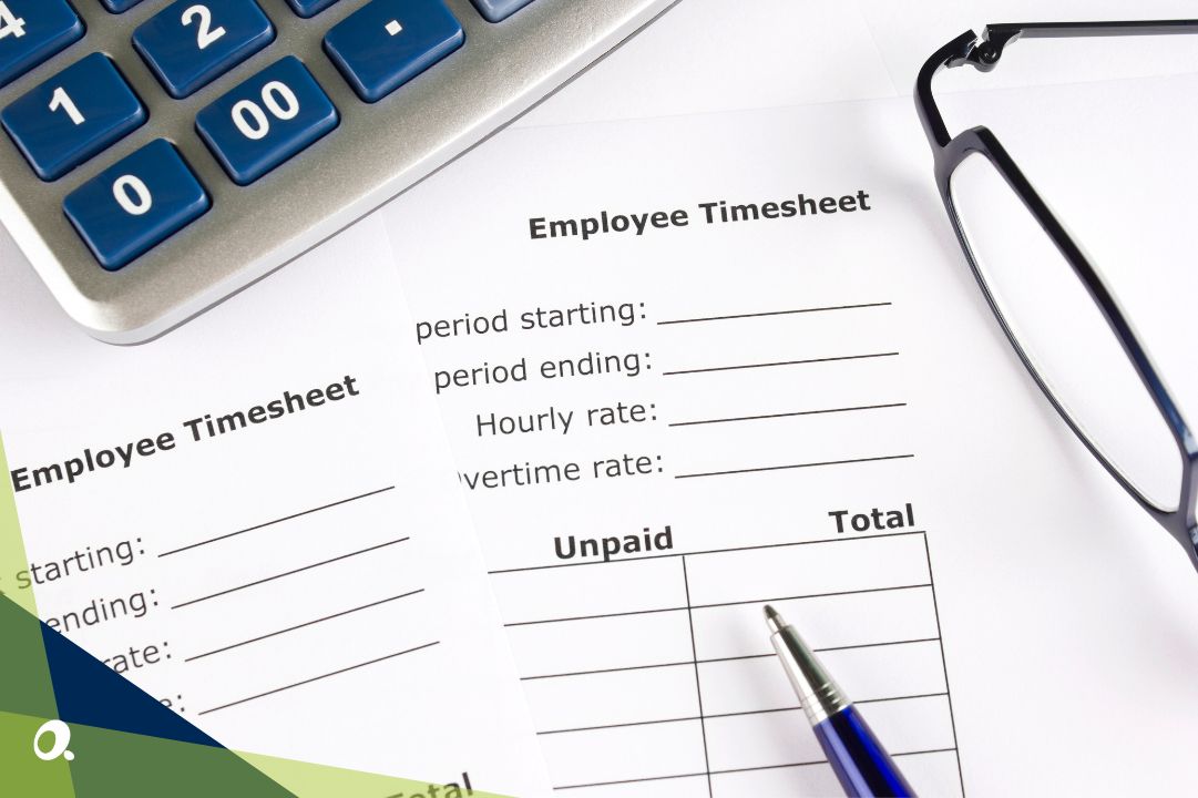 Close-up of employee timesheets on a desk with a pen, calculator, and glasses.