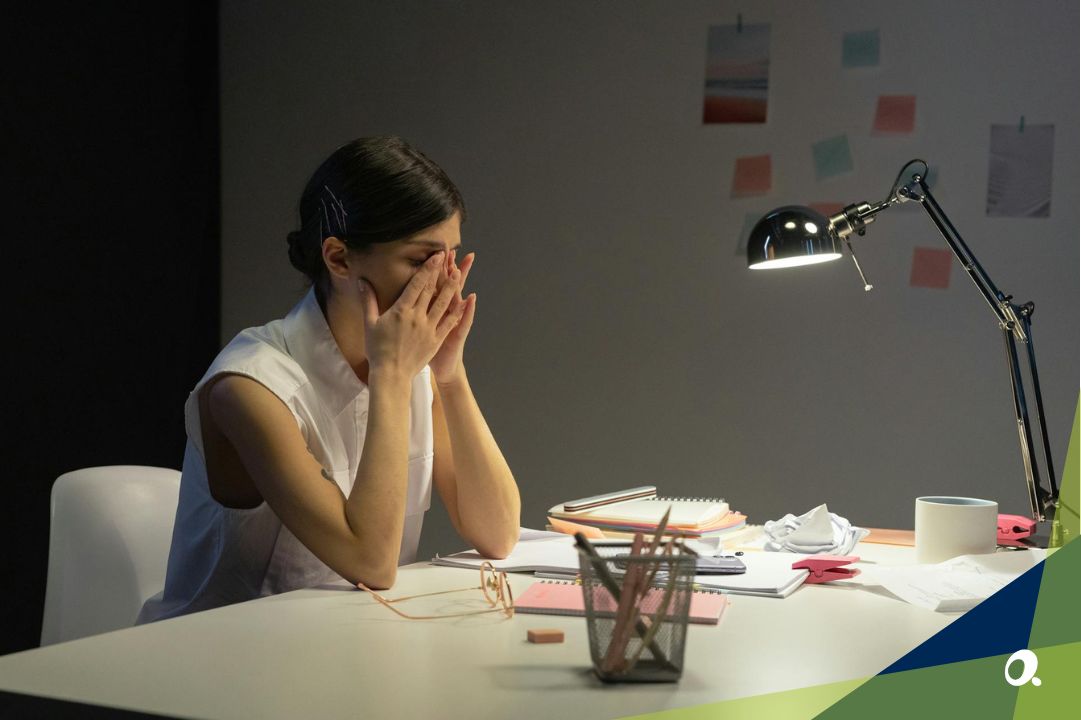 Finance professional stressed over paperwork at desk, representing slow and manual month-end close.