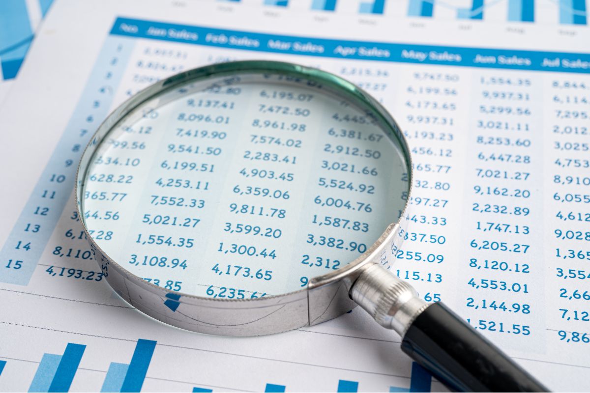 A magnifying glass sitting on top of a physical spreadsheet